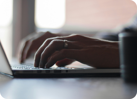 Hands typing on a laptop keyboard