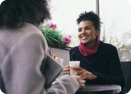 Two people chatting warmly over coffee